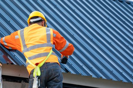 Roofing Worker Installing A Metal Roof